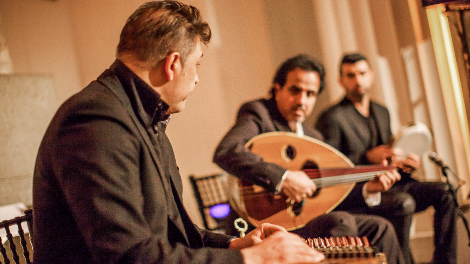Ahmed Mukhtar performing with the Taqasim Ensemble on stage.
